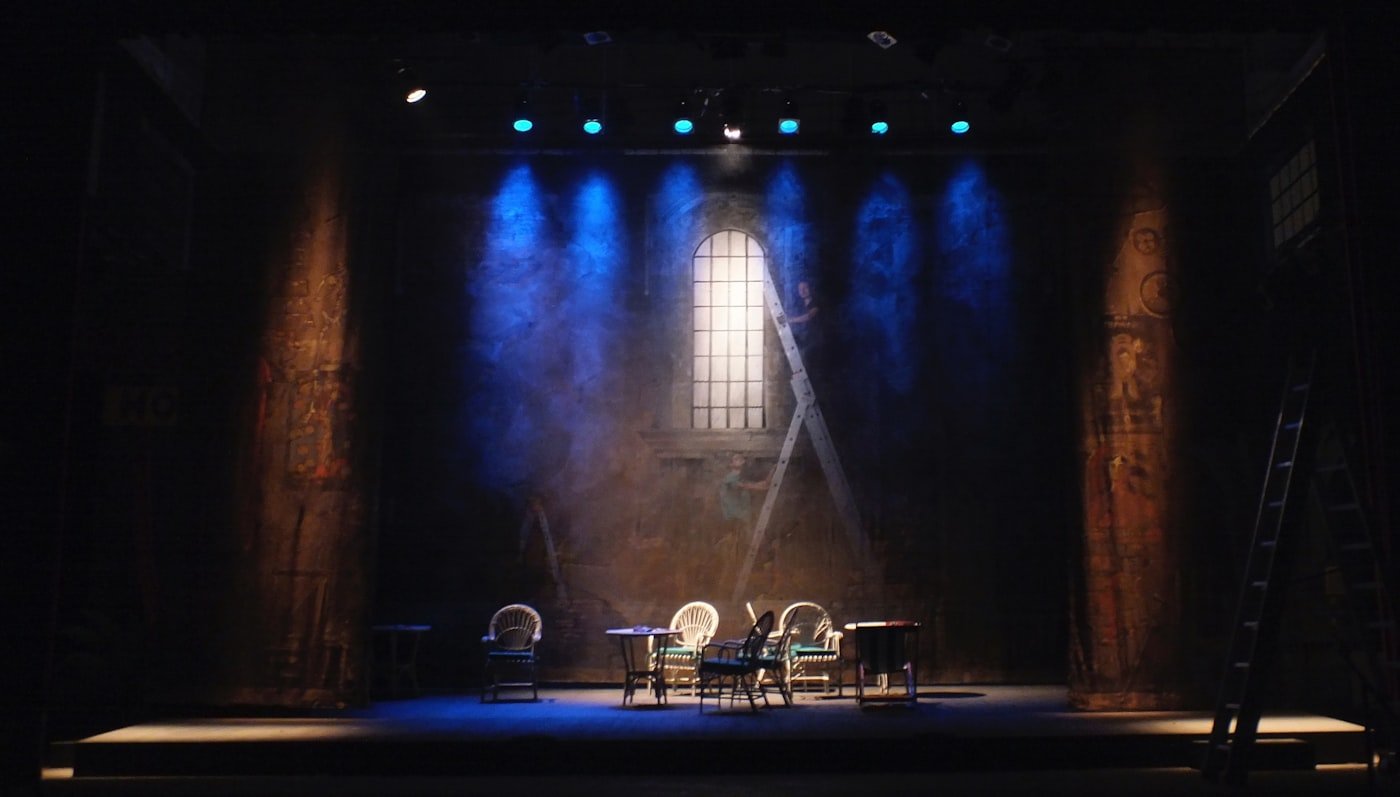 An empty theatre stage lit in blue and amber
