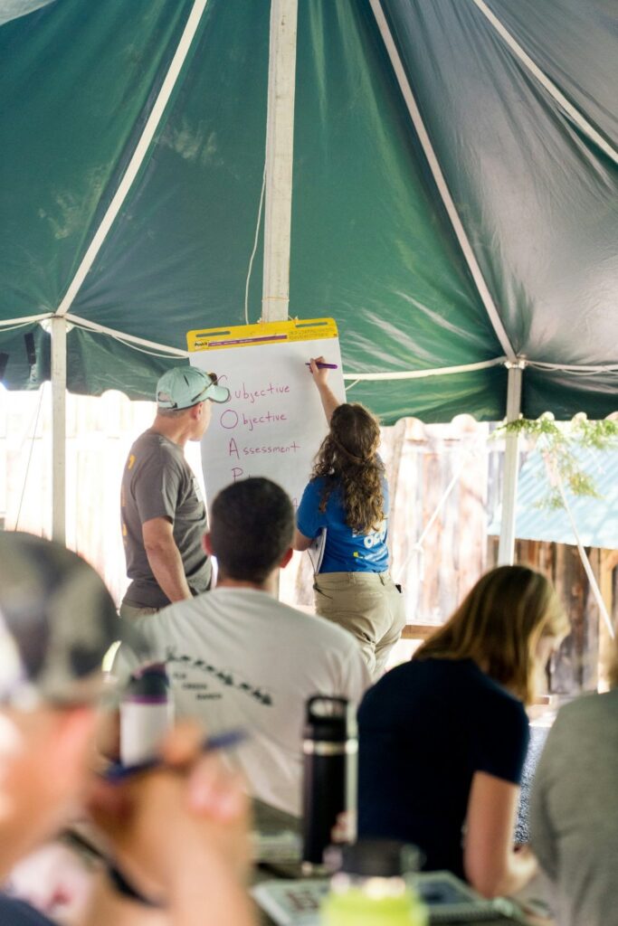 People gathered under a tent for a volunteer orientation