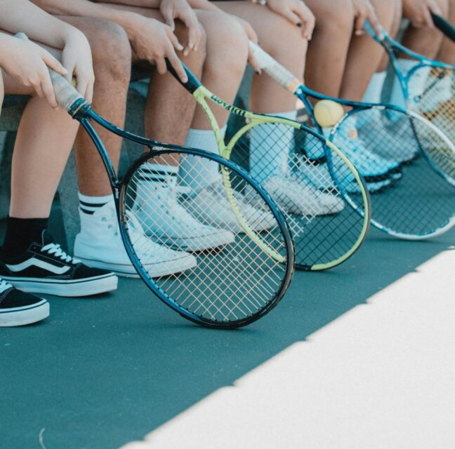 Young players with rackets courtside