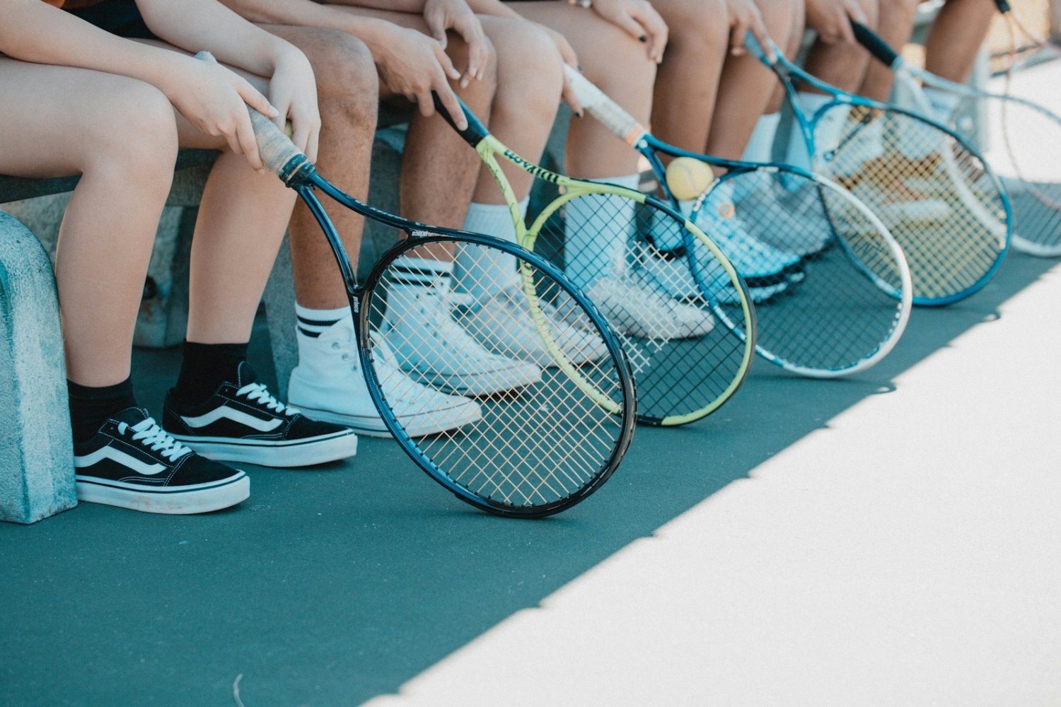 Young players with rackets courtside